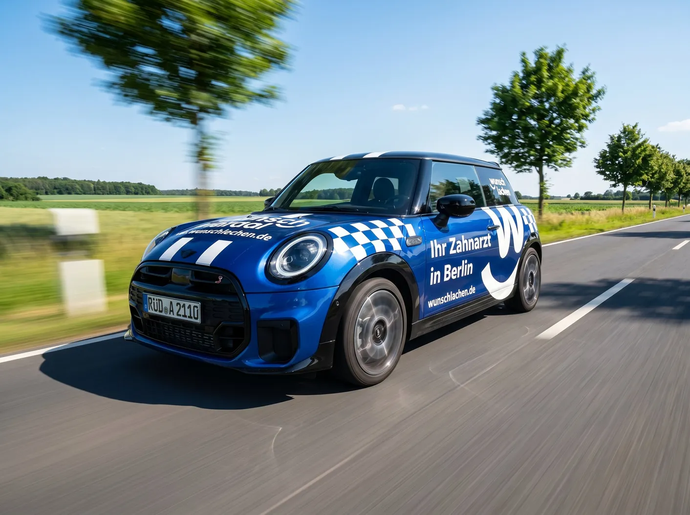 Blauer Wunschlachen-Dienstwagen mit Praxisbeschriftung auf einer Landstraße bei Berlin